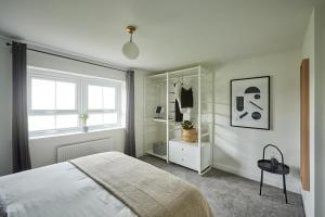 a white bedroom with a bed and a window at Coventry Home for 6+2, 150Mbp Wi-Fi + Parking in Canley