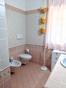 y baño con aseo, bidet y lavamanos. en Amazing house 10 min by car from the beach, en Olbia