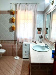 un bagno con vasca, lavandino e specchio di Amazing house 10 min by car from the beach a Olbia