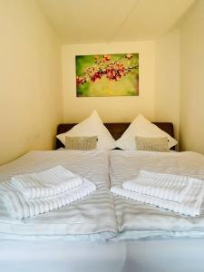 two beds with white sheets and a painting on the wall at Fewo an der Stever in Lüdinghausen