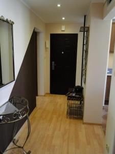 een hal met een zwarte deur en een houten vloer bij Apartament Kasprusie 65m2 in Zakopane