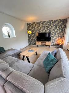 a living room with a couch and a flat screen tv at Fewo an der Stever in Lüdinghausen