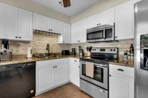 a kitchen with white cabinets and stainless steel appliances at Private oasis, Pool, Downtown PNS & Beach 3BR-2,5BT in Pensacola