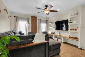 a living room with a couch and a ceiling fan at Private oasis, Pool, Downtown PNS & Beach 3BR-2,5BT in Pensacola
