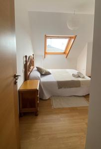a small bedroom with a bed and a window at A CUARTA RONDA in Melide