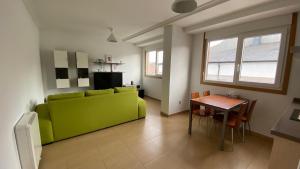 a living room with a green couch and a table at A CUARTA RONDA in Melide