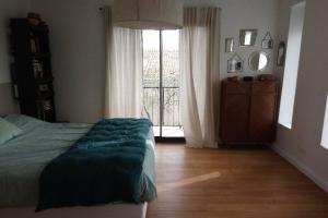 - une chambre avec un lit et une grande fenêtre dans l'établissement Maison moderne à Uzès centre ville à pied, à Uzès