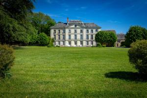 uma grande casa branca com um grande campo de relva em Château Laborde Saint Martin em Candé-sur-Beuvron