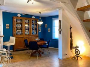 Laterale Residences Riquewihr في ريكيوير: غرفة طعام بجدران زرقاء وطاولة وكراسي