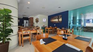 a restaurant with wooden tables and chairs and a plant at Alugar na Riviera Boulevard Flat in Riviera de São Lourenço