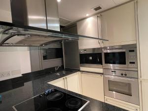 a kitchen with stainless steel appliances and black counter tops at Stunning View 2 Bed Apartment - Canary Wharf City in London