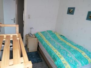 a small bedroom with a bed and a night stand at westerwarft-10 in Büsum