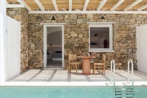 Casa con piscina y pared de piedra en Porto Mykonos, en Mykonos ciudad