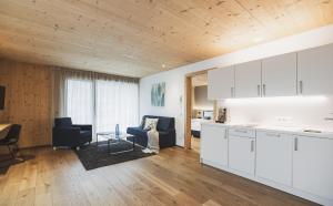 a kitchen and living room with white cabinets at Residence Nives in Bressanone