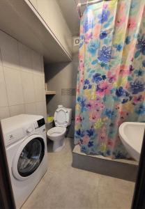 a bathroom with a washing machine and a shower curtain at Hostel Near The Square in Tbilisi City