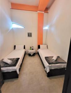 two beds in a room with orange and white walls at Hostel Near The Square in Tbilisi City