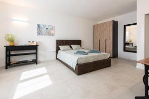 a bedroom with a bed and a wooden cabinet at Giardino del Borgo Appartamento Valpolicella in SantʼAmbrogio di Valpolicella