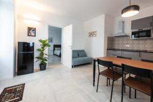 a kitchen and living room with a table and chairs at Giardino del Borgo Appartamento Valpolicella in SantʼAmbrogio di Valpolicella +27 photos