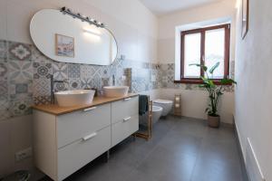 a bathroom with two sinks and a toilet at Giardino del Borgo Appartamento Valpolicella in SantʼAmbrogio di Valpolicella