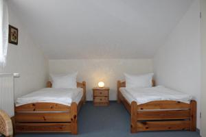 2 Einzelbetten in einem Zimmer mit einer Lampe in der Unterkunft FeWo Marion in Wustrow