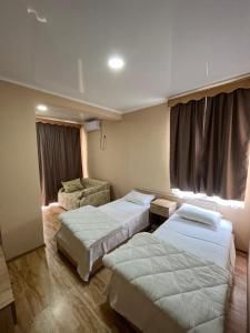 um quarto de hotel com duas camas e uma cadeira em IPPA S PLAZA em Grigoleti