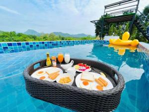 a tray of food on a table in a swimming pool at เคียงดาว โฮมสเตย์ แก่งกระจาน in Ban Song Phi Nong