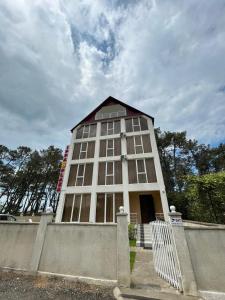 un grand bâtiment blanc avec une clôture devant lui dans l'établissement IPPA S PLAZA, à Grigoleti