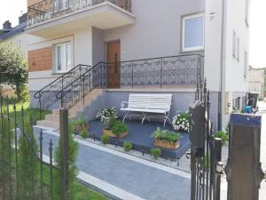 a white bench sitting in front of a house at Apartament Świerkowa in Lidzbark