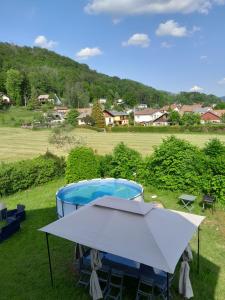 a white table and a pool in the grass at Gîte des douze mulets in Saulxures-sur-Moselotte