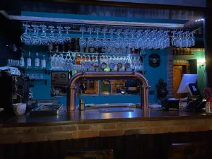 a bar with blue glasses on the wall at Mosci's Bed & Beer in San Damiano dʼAsti