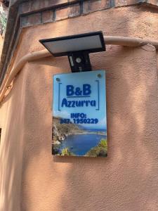 una señal en el lateral de un edificio con luz en Case vacanze Azzurra, en Marina di Camerota