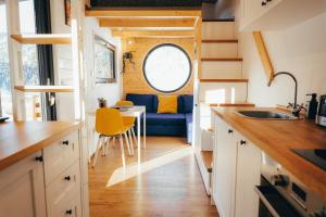 a kitchen with a table and a couch in a tiny house at Togethernest Glamping in Mătişeşti