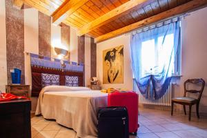 1 dormitorio con 1 cama grande y 1 maleta roja en Casa San Carlo, en Caraglio