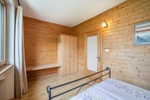 ein Schlafzimmer mit Holzwänden und ein Bett in einem Zimmer in der Unterkunft Langstein Wohnung Lavendel in Goldrain