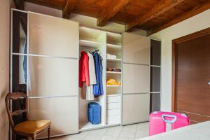 a bedroom with a closet with a pink suitcase at Casa San Carlo in Caraglio