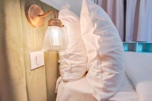 a lamp on a bed next to a pillow at Aparthotel AMMI Vieux Nice in Nice