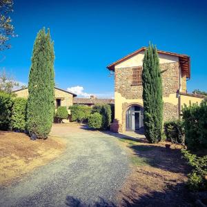 a house with two trees in front of a driveway at Agriturismo Santa Cristina in Gambassi Terme