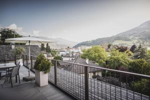 einen Balkon mit einem Tisch und einem Sonnenschirm in der Unterkunft Residence Nives in Brixen