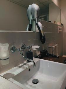 a bathroom sink with a faucet and a mirror at Hotel Resort La Rosa Dei Venti in Portopalo