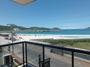 a balcony with a view of a beach and the ocean at Pousada Canto da Baleia in Arraial do Cabo