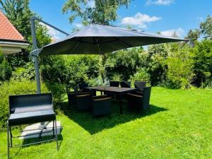 un tavolo e sedie sotto un ombrellone nell'erba di Entzückende kleine Vorstadtvilla a Klosterneuburg