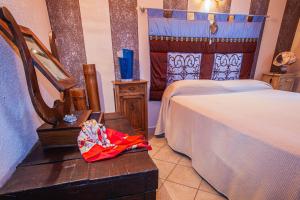 a bedroom with two beds and a table with a bag at Casa San Carlo in Caraglio