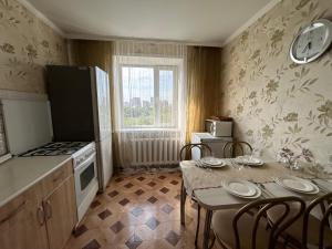 una cucina con tavolo e sedie e una sala da pranzo di 4-х комнатная квартира в центра города Астана a Astana