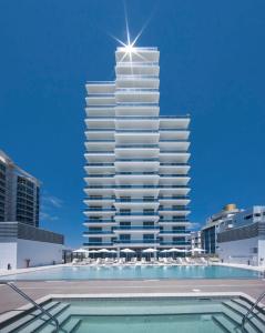 un grand bâtiment avec une piscine en face dans l'établissement Monte Carlo Miami Beach, à Miami Beach