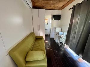 a living room with a green couch and a television at Chalet sulla spiaggia in Sottomarina