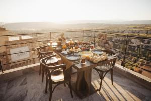 un tavolo con cibo su di esso seduto su un balcone di Olenda Cappadocia Hotel a Üçhisar