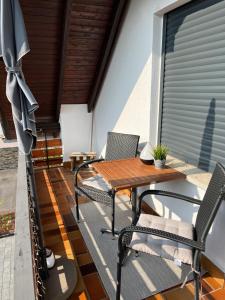 a wooden table and chairs on a patio at Ferienwohnung Christa in Bullay