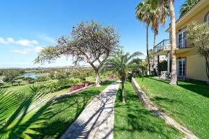 a walkway in front of a house with palm trees at Bull Vital Suites & Spa Boutique Hotel - Only Adults in Playa del Ingles