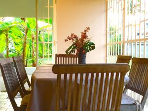 een tafel met een vaas met bloemen op een patio bij Villa avec piscine privée, calme, proche des plages, à Sainte Anne in Sainte-Anne