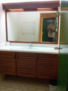 een badkamer met een wastafel en een grote spiegel bij Villa avec piscine privée, calme, proche des plages, à Sainte Anne in Sainte-Anne